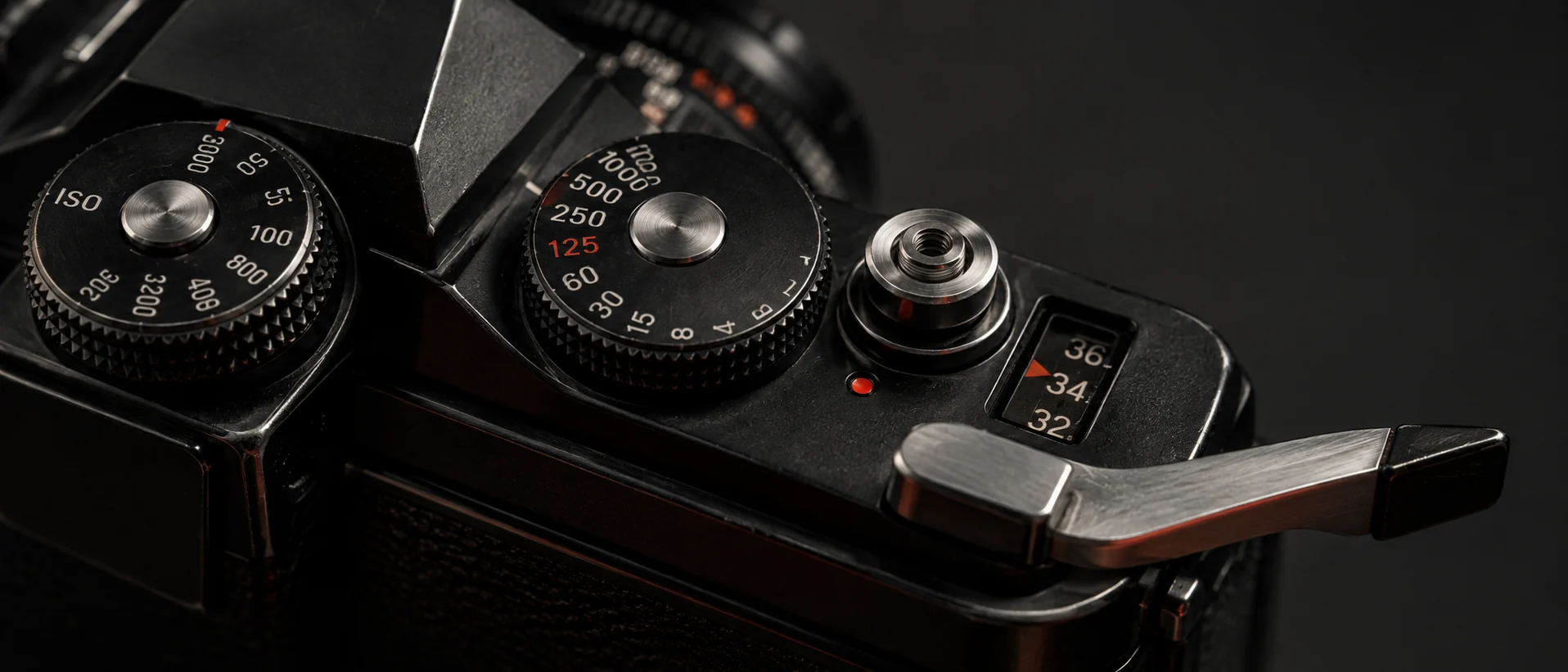 Macro detail of mechanical ISO and shutter dials with a film advance lever